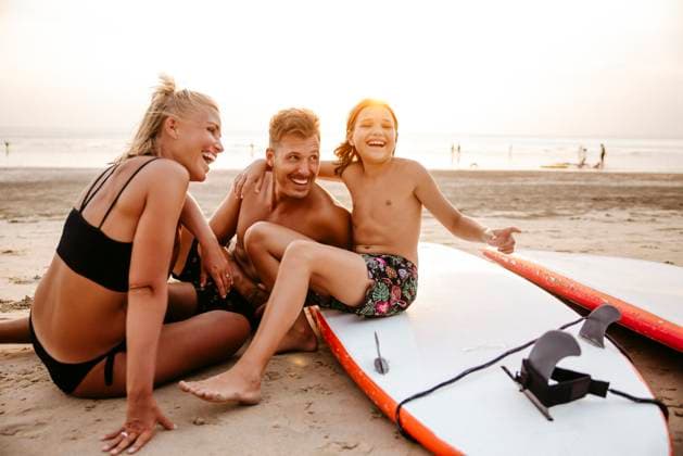 Cheerful parents enjoying with daughter sitting on paddleboard at beach during sunset Thailand, Ko Lanta, model released Copyright: xMaskotx , MA100547 MA100547