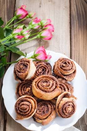 Cinnamon rolls Cinnamon buns and pink roses on a wooden background Copyright: xZoonar.com BurakovaxIrinax 13341143