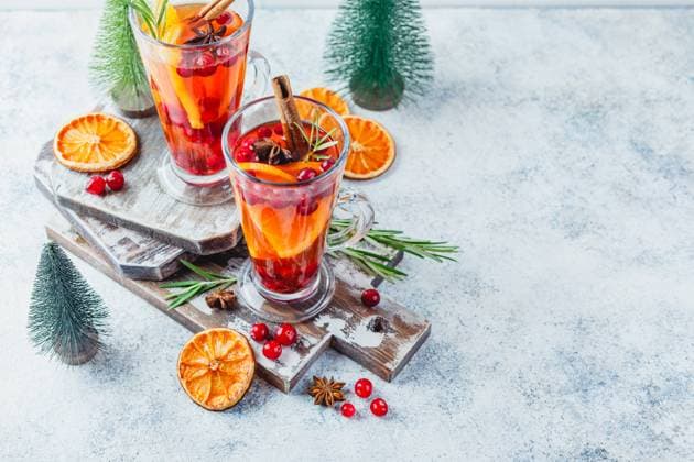 Orange and cranberry drinks with orange slices and spices. Hot drinks for winter and Christmas Hot tea with orange slices and cranberries in glass tall glasses. Hot drinks for winter and Christmas. Place for text. Copyright: xZoonar.com BurakovaxIrinax 16409742
