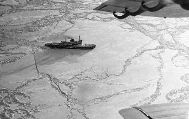 January, 1966. USSR. A view of the Moskva icebreaker as seen from the Antonov An-2 aircraft, piloted by Georgy Grachev, who deliveris letters and newspapers to the icebreaker crew. The icebreaker moves through drift ice of the Sea of Okhotsk to Nagaev Bay. The exact date of the photograph is unknown. Yuri Muravin TASS  18767900