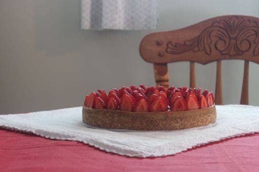 RECORD DATE NOT STATED A closeup shot of a cake decorated with slices of strawberries against a wooden chair *** einer closeupe erschossen des einer Kuchen verziert mit slices des Erdbeeren gegen einer hölzern Stuhl 15753359