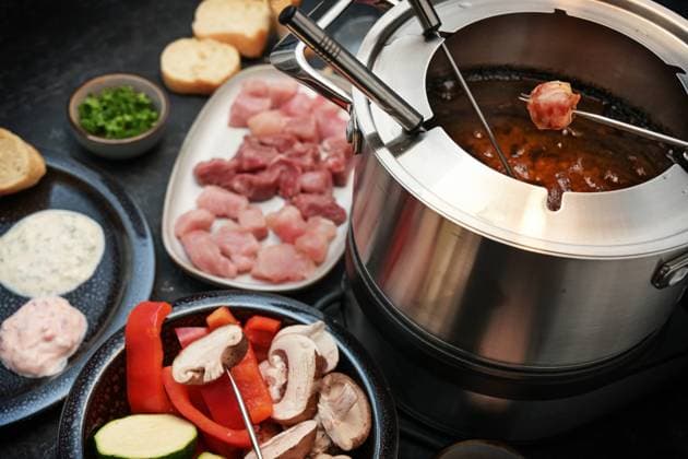 German fondue with raw meat and vegetables to be fried on long forks in a pot with boiling oil, often served for family and friends on holidays like New Year, selected focus German fondue with raw meat and vegetables to be fried on long forks in a pot with boiling oil, often served for family and friends on holidays like New Year, selected focus, narrow depth of field Copyright: xZoonar.com MARENxWINTERx 19404083
