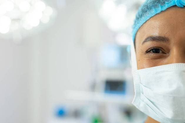 Half portrait of smiling biracial female surgeon in mask and cap in operating theatre, copy space Half portrait of smiling biracial female surgeon in mask and cap in operating theatre, copy space. Hospital, medical and healthcare services., model released, , property released, Cape Town, South Africa, 2022-10-21T22:00:00.000Z, 3876550.jpg, people,half,portrait,smiling,biracial,female,surgeon,mask,cap,operating,theatre,copy space,hospital,medical,healthcare,service,doctor,medicine,clinic,care,health,patient,treatment,nurse,surgery,illness,disease,surgical,operation,specialist,virus,professional,coronavirus,uniform,stethoscope,face,copy,space Mid Adult,Woman,Female,Black
