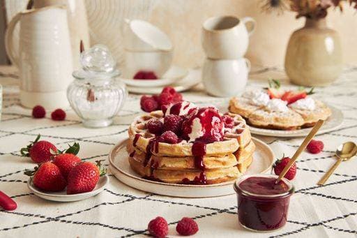 RECORD DATE NOT STATED A soft focus of delicious waffles with vanilla ice cream, strawberries and raspberries on a breakfast table *** einer weich Fokus des Köstlich Waffeln mit Vanille Eis cream, Erdbeeren und Himbeeren am einer Frühstück Tisch 1687458