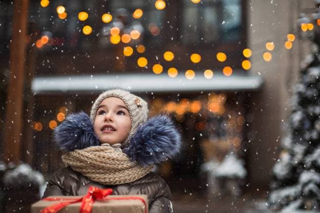 IMAGO Creative, Jahreszeit Winter in der Stadt Portrait of joyful girl with a gift box for Christmas on a city street in winter with snow on a festive market with decorations and fairy lights. Warm clothes, knitted hat, scarf and fur. New year Portrait of joyful girl with a gift box for Christmas on a city street in winter with snow on a festive market with decorations and fairy lights. Warm clothes, knitted hat, scarf and fur. New year ,model released, Symbolfoto Copyright: xZoonar.com OLGAxSIMONOVAx 19410413 ,model released, Symbolfoto ,property released