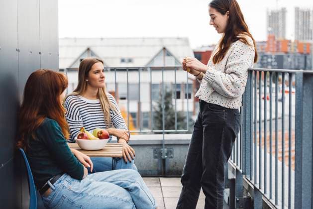 IMAGO Creative, Lifestyle, Leben in einer Wohngemeinschaft, WG Group of friends, college students on a balcony of their dorm room Young caucasian woman college students, sitting on the rood top of their dorm room, eating a snack taking a break from studying, getting some fresh air, on a cloudy autumn day. ,model released, Symbolfoto Copyright: xZoonar.com ZigaxPlahutarx 19517732 ,model released, Symbolfoto ,property released