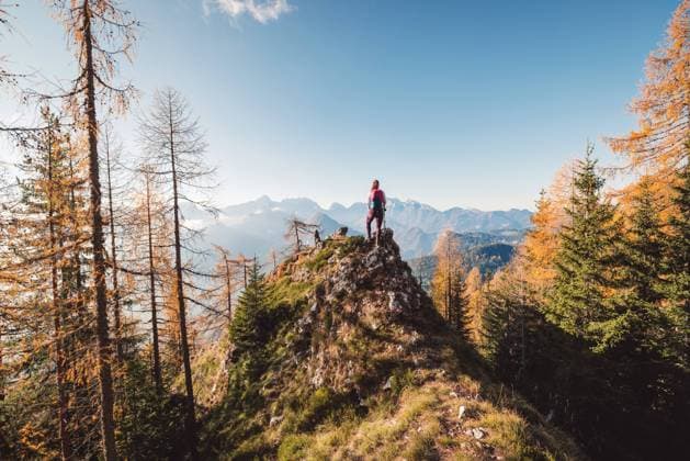 Majestic view of lonley woman hiker standing on top of the hill, autumn forest surrounding her, looking at the view of the mountains in the background Scenic view of autumn mountain, European Alps, from a view point, where caucasian woman hiker is standing. Sun is shining high up in the mountains, a light mist in the valleys down bellow. Woman mountaineer enjoying the view of majestic Alps on a sunny autumn day. ,model released, Symbolfoto Copyright: xZoonar.com ZigaxPlahutarx 19539175 ,model released, Symbolfoto ,property released