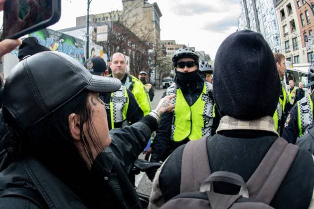 April 5, 2023, Vancouver, British Columbia, Canada: A demonstrator swears at Vancouver police officers on Hastings Street in Vancouver, Canada, as police and city crews remove a homeless encampment April 5. The City of Vancouver requested a heavy police presence for the safety of crews clearing the tents, temporary structures and personal effects of homeless residents who have camped on the sidewalk for about eight months, sometimes blocking the entrances of businesses and residencies. The move follows the closure of encampments in public parks two years ago at the onset of whatÃ¢â‚¬â ¢s now CanadaÃ¢â‚¬â ¢s worst affordable housing crisis. Motivating the latest sweep, officials cited a spike in fires, assaults, robberies and other public s - ZUMAb217 20230405_zip_b217_006 Copyright: xQuinnxBenderx