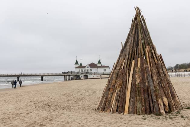 Ostern an der Ostsee 2023 Ahlbeck, Deutschland 8. April 2023: Für das heute Abend stattfindende Osterfeuer ist am Strand Holz zum Entzünden vorbereitet worden, während Menschen am Ostersamstag an der Ostsee bei niedrigen Temperaturen spazieren gehen. Mecklenburg-Vorpommern