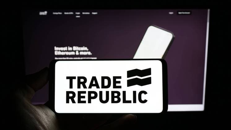 Person holding cellphone with logo of German company Trade Republic Bank GmbH on screen. Stuttgart, Germany - 01-07-2023: Person holding cellphone with logo of German company Trade Republic Bank GmbH on screen in front of business webpage. Focus on phone display. Copyright: xZoonar.com TimonxSchneiderx 19686235