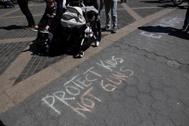 April 9, 2023, New York, New York, USA: Pedestrians pass chalking on the plaza that reads Protect Kids Not Guns. Demonstrators with Rise & Resist, Gays Against Guns and supporters stood in Columbus Circle on Easter Sunday to protest the expulsion of Justin Jones And Justin Pearson from the Tennessee state legislature this week. The two Black Democrats were ousted by the Republican majority legislature for calling for gun law reform in the House after the Nashville school shooting. Gloria Johnson, a White member of the legislature who also protested against gun violence was not expelled. New York USA - ZUMAr174 20230409_znp_r174_045 Copyright: xGinaxMxRandazzox