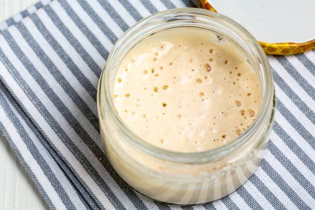 Mature sourdough in jar. Artisanal wheat sourdough starter. Top view of glass jar with sourdough starter close up,selective focus. Copy space. Copyright: xZoonar.com MarinaxSaprunovax 19721923