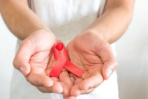 RECORD DATE NOT STATED A closeup shot of a young man holding a red ribbon - world AIDS day concept *** einer closeupe erschossen des einer Jung Mann haltend einer Roter Farbband Welt aidskranken Tag Konzept 1142589