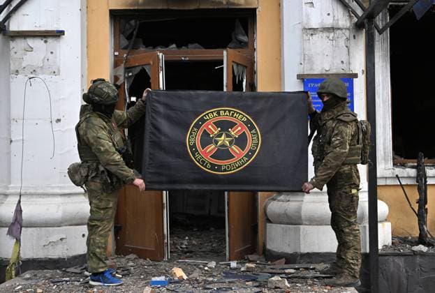 Russia Ukraine Military Operation Wagner Group 8410095 09.04.2023 Servicemen of Russia s private military company Wagner Group hold their flag near the building of local administration in Artyomovsk, also known as Bakhmut, as Russia s military operation in Ukraine continues, Donetsk People s Republic, Russia. Evgeny Biyatov Sputnik Artyomovsk Luhansk People s Republic  Copyright: xEvgenyxBiyatovx