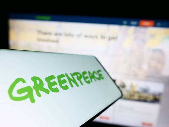 Mobile phone with logo of environmental campaigning network Greenpeace on screen in front of website Stuttgart, Germany - 01-26-2023: Mobile phone with logo of environmental campaigning network Greenpeace on screen in front of website. Focus on left of phone display. Copyright: xZoonar.com TimonxSchneiderx 19789999