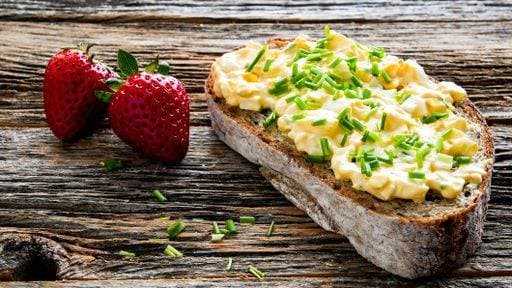 RECORD DATE NOT STATED Bread with eggs salad and chives and two strawberry on rustic old wooden table with copy space *** Brot mit Eier Salat und Schnittlauch und Zwei Erdbeere am Rustikal Alte hölzern Tisch mit Kopie Weltraum 10534983