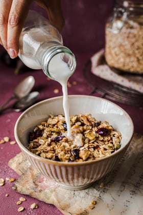 Bowl of granola with an old spoon on a purple backgroud, served with a drip of milk Bowl of granola with an old spoon on a purple backgroud, served with a drip of milk Copyright: xx ST060323-24