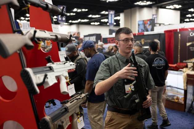 April 15, 2023, Indianapolis, Indiana, United States: A worker shows a rifle at the Tokarev booth during the National Rifle Association s Annual Meetings & Exhibits at the Indiana Convention Center in Indianapolis. The forum is part of the National Rifle Association™s Annual Meetings & Exhibits which is expected to draw around 70,000 guests, opens today and runs through Sunday. Indianapolis United States - ZUMAs197 20230415_zaa_s197_004 Copyright: xJeremyxHoganx