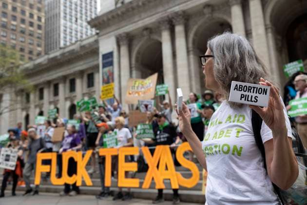 Bilder des Jahres 2023, News 04 April News Themen der Woche KW15 News Bilder des Tages April 15, 2023, New York, New York, USA: A protester holds a box that reads Abortion Pills. A sign reads Ã¢â‚¬oeFuck Texas.Ã¢â‚¬Â On a national day of action to protest the court battle to restrict access to mifepristone, used for medication abortion, pro-abortion activists rallied on the steps of the 42nd St branch of the New York Public Library to call for an end to abortion bans. New York USA - ZUMAr174 20230415_znp_r174_079 Copyright: xGinaxMxRandazzox