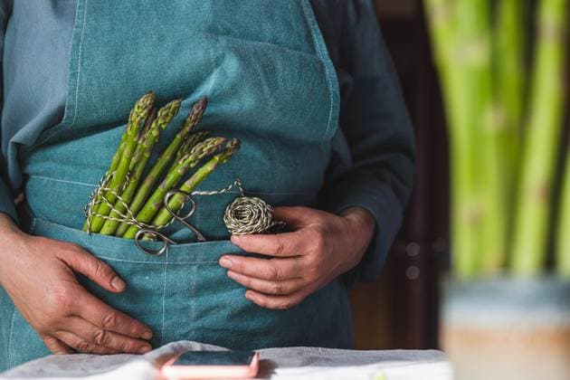 IMAGO Creative: Food, Spargel a woman in an apron will cook asparagus and reads a recipe Öhringen, Baden-Württemberg, Germany CR_DVHK230411-1169228-01