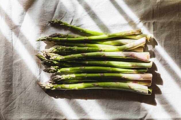 IMAGO Creative: Food, Spargel Green fresh asparagus lies on a linen tablecloth,sunny light . Öhringen, Baden-Württemberg, Germany R_DVHK230411-1169227-01