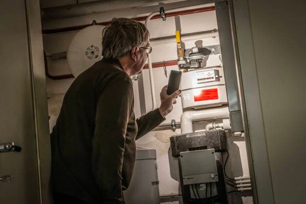 Private Gasheizung, Mann liest den Gaszähler ab, München, April 2023 Deutschland, München, April 2023, Mann liest Gaszähler in seinem Heizungsraum ab, leuchtet mit der Handy-Taschenlampe auf den Gaszähler, Energieverbrauch, Gasverbrauch, Erdgasheizung mit Warmwasserspeicher in einer Privatwohnung, Heizungsanlage, für Raumtemperatur und Warmwasser, betrieben mit Erdgas, älterer Mann, Ü60, 60-70, Symbol privater Gasverbrauch, Gaspreise, Wärmewende, Heizungstausch, Abschied von alten Gasheizungen, Energie sparen, Energiesparen, Energiekrise, Bayern, *** Private gas heating, man reads gas meter, Munich, April 2023 Germany, Munich, April 2023, man reads gas meter in his boiler room, shines cell phone flashlight on gas meter, energy con