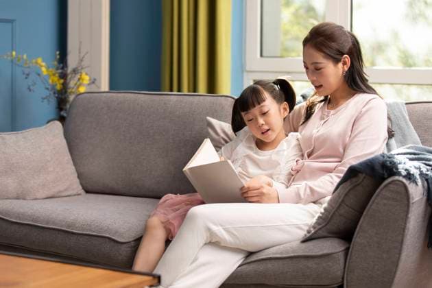 RECORD DATE NOT STATED Young Chinese mother and daughter reading book at home Beijing China Copyright: xLanexOateyx bji06570118