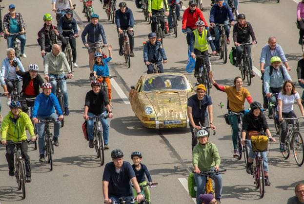 Rad-Sternfahrt des ADFC, Teilstück über die Autobahn A96, München, 23. April 2023 Deutschland, München, 23. April 2023, große Rad-Sternfahrt des ADFC, hier auf der gesperrten Autobahn A 96 bei München-Laim, Teilnehmer mit goldenem Tretauto und Nummernschild Kein Auto, , Fahrraddemo für die Unterstützung des Volksbegehrens Radentscheid Bayern , Motto der Fahrrad-Demo: gemeinsam Radeln für eine bayernweit bessere Radinfrastruktur, Teilstück über die A96 von Sendling bis zur Ausfahrt Blumenau, Verkehr, Fahrrad fahren, Verkehrswende, Umwelt, Klimaschutz, Bayern,