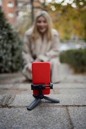 Smart phone mounted on tripod with woman vlogging in background model released, Symbolfoto, JJF00660