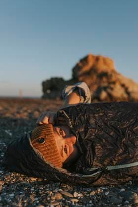 Woman wearing knit hat in sleeping bag at beach model released, Symbolfoto, DMGF01116