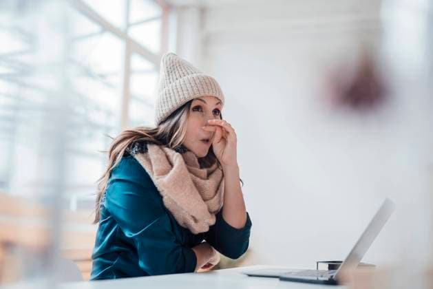Sick businesswoman wiping nose sitting in front of laptop at home office model released, Symbolfoto property released, JOSEF17756