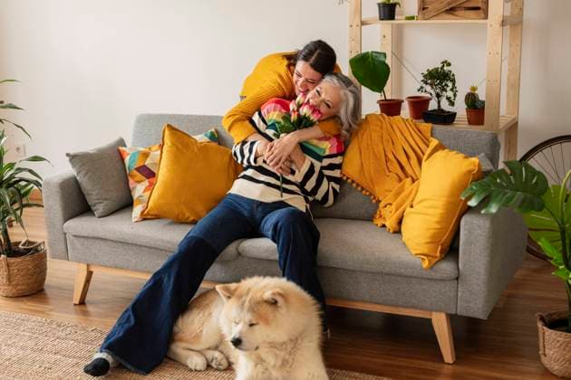 Happy daughter giving flowers and hugging mother at home model released, Symbolfoto property released, JCCMF10136