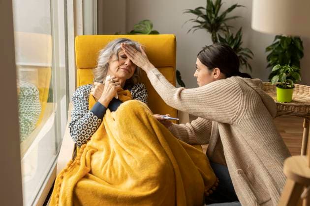Daughter examining temperature of ill mother at home model released, Symbolfoto property released, JCCMF10162