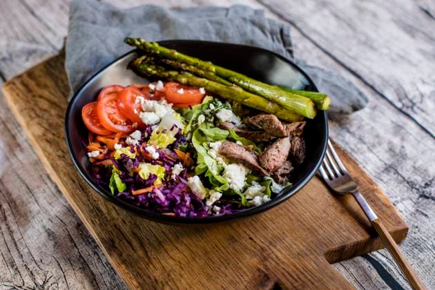 Bowl of salad with steak, asparagus, tomatoes, shredded red cabbage, lettuce and feta cheese, SBDF04609