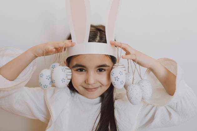 Smiling girl holding Easter eggs in front of wall model released, Symbolfoto property released, VBUF00301