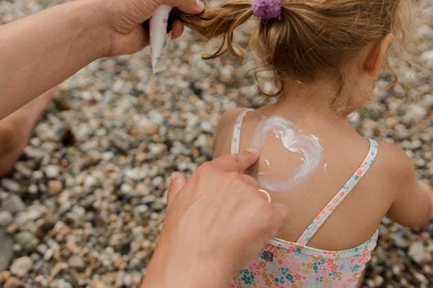 IMAGO Creative, Jahreszeit Sommer, Sonnenschutz Man drawing heart shape with suntan lotion on daughter model released, Symbolfoto, VIVF00523
