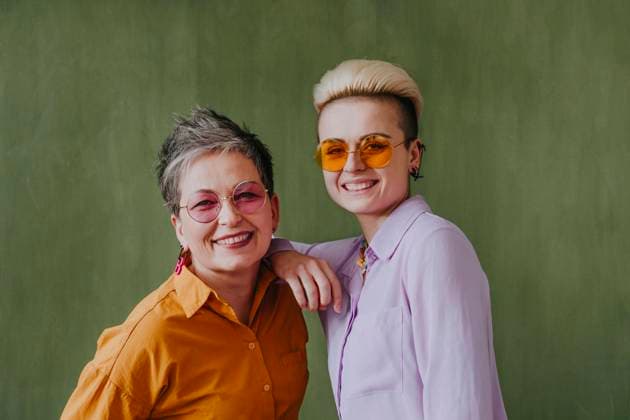 Happy young woman with hand on mother s shoulder standing in front of wall model released, Symbolfoto property released, YTF00718