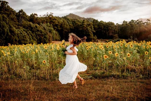 Creative Highlights Symbolbilder Young girl in flowy white dress dancing in field of sunflowers Penguin, Tasmania, Australia R_YEEN230324-1158599-01 ,model released, Symbolfoto