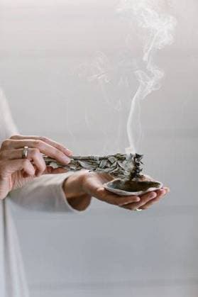IMAGO Creative, Lifestyle, Esoterik gefährlicher Glaube RECORD DATE NOT STATED A vertical shot of a woman burning sage and holding it over a seashell. *** einer hoch erschossen des einer Frau brennend Salbei und haltend es trueber einer seashell 2716405