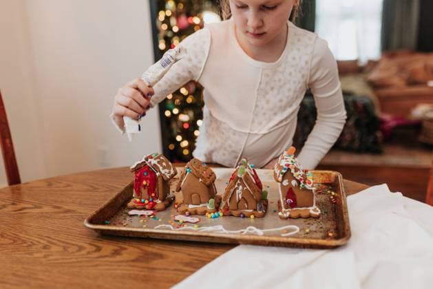 Young girl decorates gingerbread houses at kitchen table Sioux Falls, South Dakota, United States CR_ASWE230317-1125880-01 ,model released, Symbolfoto ,property released