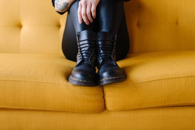 Creative Highlights Symbolbilder Up close of black boots side by side pulled up onto yellow couch Portland, Oregon, United States CR_OQLW230320A9-1155540-01 ,model released, Symbolfoto