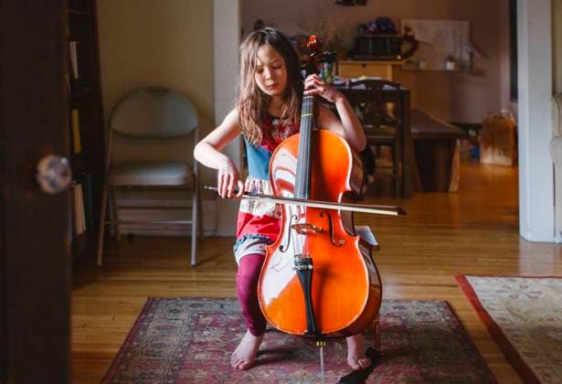 Creative Highlights Symbolbilder A young barefoot girl plays cello passionately with eyes closed Columbus, Ohio, United States CR_RETI230320-1116630-01 ,model released, Symbolfoto