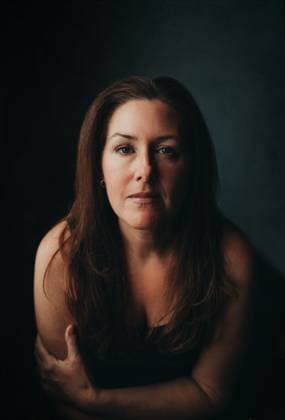 Creative Highlights Symbolbilder Portrait of attractive woman with long brown hair against dark wall. Kingston, Ontario, Canada R_DOHO230322-1157730-01 ,model released, Symbolfoto
