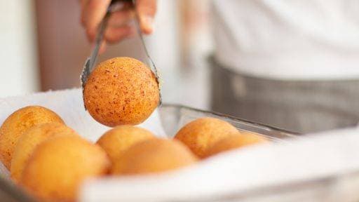 A closeup of a person taking bunuelos with tongs from a tray in the kitchen *** einer closeupe des einer person nehmend bunuelos mit tongs von einer Tablett ÊIn der Küche 2867863