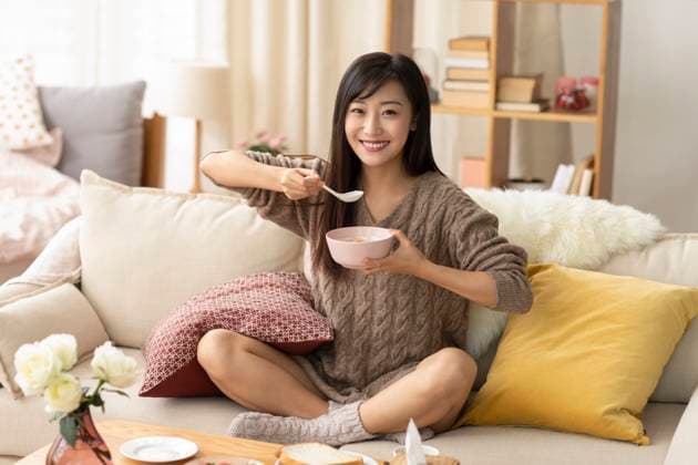 Young Chinese woman having breakfast at home Beijing China Copyright: xLianxFeix bji06030028