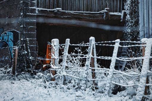 RECORD DATE NOT STATED A wooden fence standing in the snow in front of a building, with a blanket of snow on the rooftop *** einer hölzern Zaun stehend ÊIn der Schnee ÊIn vorne des einer building, mit einer blanket des Schnee am der rooftop 16367176