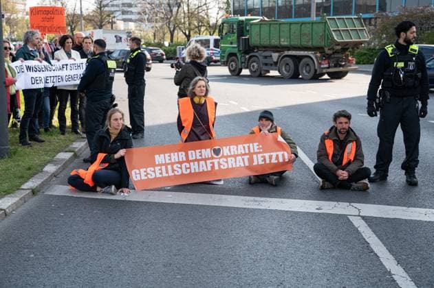 News Themen der Woche KW17 News Bilder des Tages 28.04.2023, Berlin, Deutschland, Europa - Klimademonstranten der so genannten Letzten Generation kleben auf der Fahrbahn einer Hauptstrasse am Ernst-Reuter-Platz in Berlin-Charlottenburg und verursachen schwere Verkehrsbehinderungen. Die Hauptforderungen der Aktivisten sind ein erschwingliches 9-Euro-Ticket fuer alle und ein generelles Tempolimit von 100 km h auf deutschen Autobahnen. Die Gruppe fordert zudem die Bundesregierung auf, drastischere Massnahmen zur Senkung der Treibhausgasemissionen zu ergreifen und bis 2030 die Nutzung aller fossilen Brennstoffe einzustellen, sowie einen Gesellschaftsrat. *** 28 04 2023, Berlin, Germany, Europe Climate protesters of the so-called Last Generation are stuck on the roadway of a main street at Ern