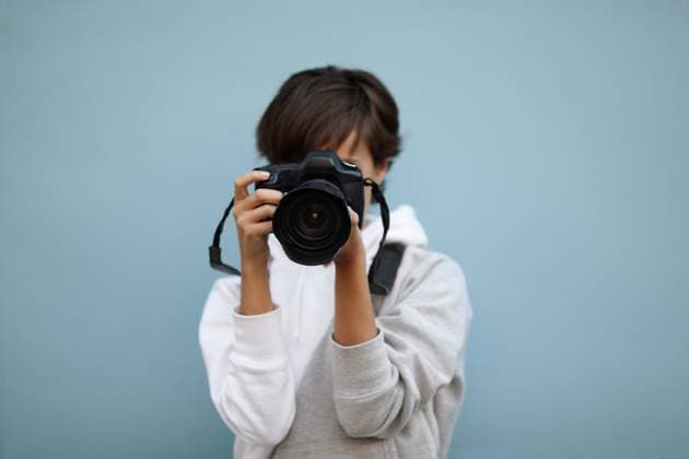 young woman with professional camera, selective focus on nearest part of lens Copyright: xAlexeyxKlementievx xDesignxPicsx , 30564643 Copyright: ErikxReisx xDesignxPics 30564643