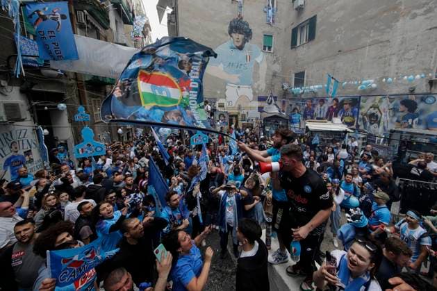 Supporters cheer next to a mural painting depicting Diego Armando Maradona waiting for the result of the SSC Napoli vs US Salernitana soccer match. After SS Lazio s defeat to FC Inter, Napoli could win the Italian Serie A soccer championship today.  Copyright: xSalvatorexLaportax xipa-agency.nx xKontrolabx IPA_IPA37643770