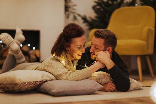 RECORD DATE NOT STATED Man and woman lying on the floor in Christmas decor *** Mann und Frau liegendes am der Boden ÊIn Weihnachten Dekor 3241100 ,model released, Symbolfoto